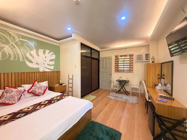 Double room with wood-look flooring, a desk and air-conditioning