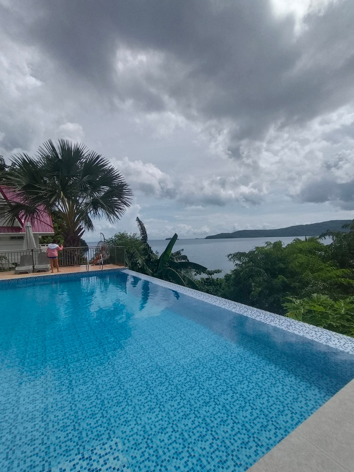 Infinity pool overlooking the cove on an overcast day at Guisian Cove Resort