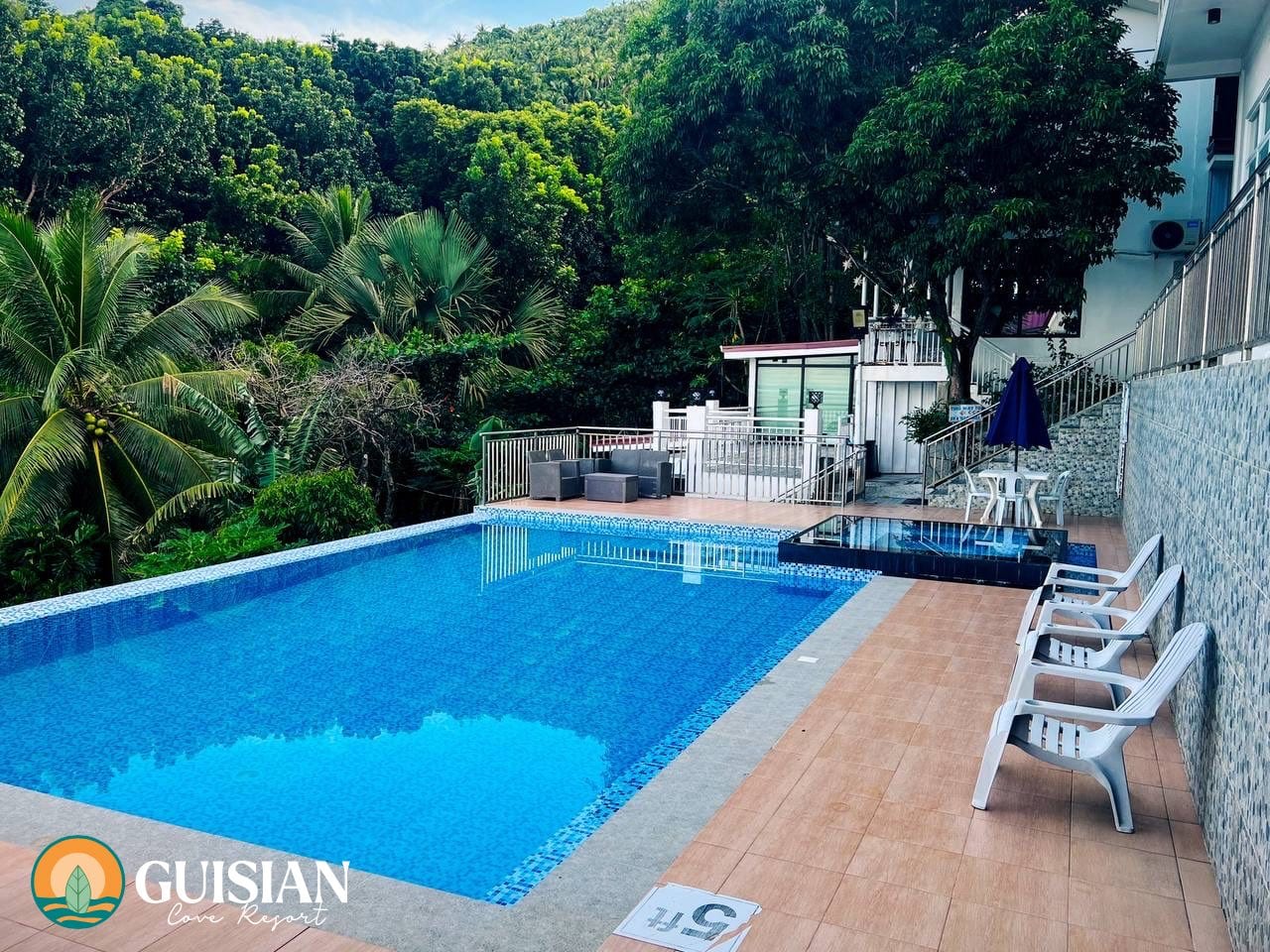 Outdoor swimming pool with mountainside greenery and lounge chairs at Guisian Cove Resort