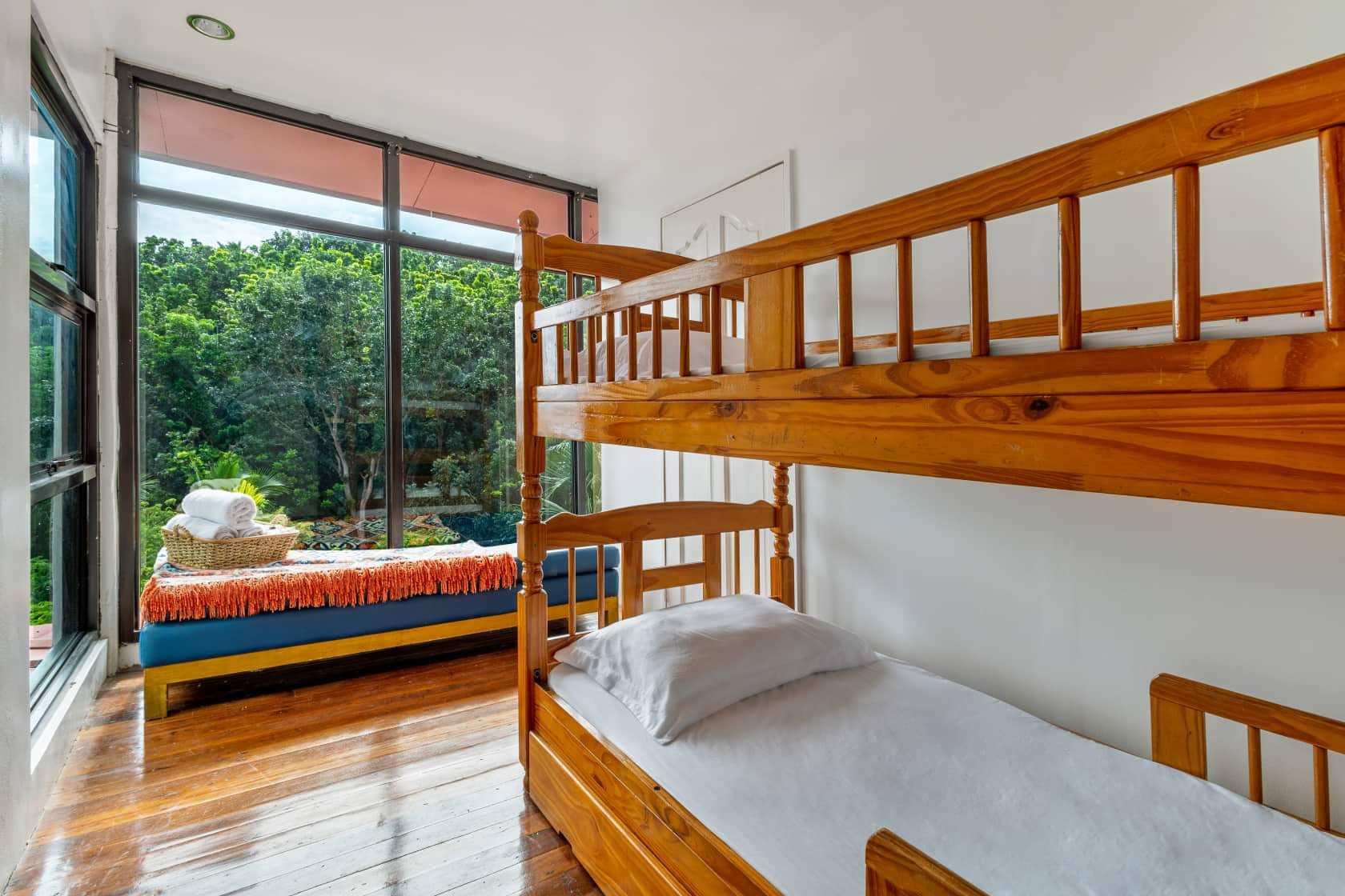 Bunk-bed bedroom at Guisian Cove Resort with hardwood floors and a window day-bed overlooking the garden